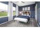 Stylish bedroom with a navy accent wall, large windows, a decorative bench, and soft carpet flooring at 1516 Tamarisk Ln, Durham, NC 27703