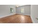 Light-filled bedroom with hardwood flooring and two large windows offering views of the surrounding greenery at 1600 Pineview St, Raleigh, NC 27608