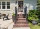 Charming home entrance featuring brick steps, black railings, and a solid wood front door at 1600 Pineview St, Raleigh, NC 27608