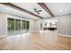 Spacious open-concept living area with hardwood floors, wood beams, and sliding doors to the patio at 1600 Sweetwater Ln, Raleigh, NC 27610