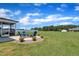 Lush backyard with a blue Adirondack chairs around a stone fire pit, perfect for relaxation and enjoying the outdoors at 175 Steep Rock Dr, Willow Springs, NC 27592