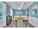 Dining room with a wooden table set for six, blue walls, white trim, and window with natural light at 175 Steep Rock Dr, Willow Springs, NC 27592