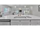 Modern kitchen featuring an oversized island with a stainless steel sink, quartz countertops, and gray cabinetry at 175 Steep Rock Dr, Willow Springs, NC 27592