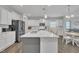 Bright kitchen with a large island, stainless steel appliances, white cabinets, and an adjacent dining area at 175 Steep Rock Dr, Willow Springs, NC 27592
