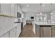 Bright, modern kitchen with white cabinetry, stainless steel appliances, and open layout to living area at 175 Steep Rock Dr, Willow Springs, NC 27592