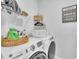 Efficient laundry room with modern washing machine and dryer, storage shelves, and convenient laundry care guide at 175 Steep Rock Dr, Willow Springs, NC 27592