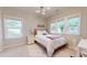 Bright bedroom with three windows, a full-sized bed with white bedding, and a modern light fixture at 1880 Woodall Crest Dr, Apex, NC 27502