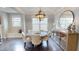 Cozy dining area with a round table, chandelier lighting, natural light, and hardwood floors at 1880 Woodall Crest Dr, Apex, NC 27502