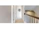 Upstairs hallway with carpet, a wood banister, and doors leading to various rooms at 1880 Woodall Crest Dr, Apex, NC 27502