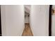 Hallway with white walls and wood laminate flooring with a glimpse of a closet in the distance at 1880 Woodall Crest Dr, Apex, NC 27502