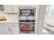 Modern stainless steel microwave and oven appliances; white cabinetry and wall tiles; a modern design at 1880 Woodall Crest Dr, Apex, NC 27502