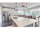 Modern kitchen island with stainless steel appliances and elegant lighting fixtures above the dining area at 1880 Woodall Crest Dr, Apex, NC 27502