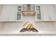 Gas stovetop and range hood with subway tile backsplash; modern white countertops and cabinets above at 1880 Woodall Crest Dr, Apex, NC 27502