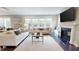Elegant living room with a fireplace, large windows, and a view to the dining space; features an area rug at 1880 Woodall Crest Dr, Apex, NC 27502
