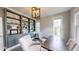 Chic home office featuring built-in shelving, soft gray walls, modern light fixture, and elegant decor for a productive workspace at 1880 Woodall Crest Dr, Apex, NC 27502