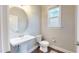 Powder room with a pedestal sink, an oval mirror, a window, and hardwood floors at 1880 Woodall Crest Dr, Apex, NC 27502