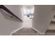 Carpeted stairs leading to a living room with a gray sofa and ottoman at 1880 Woodall Crest Dr, Apex, NC 27502