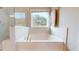 A soaking tub sits under a window, next to a large glass shower at 1880 Woodall Crest Dr, Apex, NC 27502