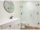 This modern bathroom offers a stand up glass shower and a round mirror at 205 Gentry St, Roxboro, NC 27573
