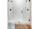 Modern bathroom featuring glass shower, matte black hardware, and wood-look floors at 205 Gentry St, Roxboro, NC 27573