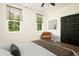 Comfortable bedroom with an upholstered chair, black closet doors and two bright windows at 205 Gentry St, Roxboro, NC 27573
