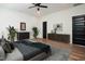 A staged bedroom features hardwood flooring, furniture and a ceiling fan at 205 Gentry St, Roxboro, NC 27573