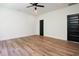 The light bright bedroom features hardwood flooring, ceiling fan and contrasting black doors at 205 Gentry St, Roxboro, NC 27573