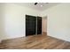 Bedroom featuring hardwood flooring, a ceiling fan, and black closet doors at 205 Gentry St, Roxboro, NC 27573