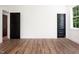Wood floors in a bright room, with two dark doors and a window at 205 Gentry St, Roxboro, NC 27573