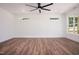 A bright bedroom is enhanced by beautiful wood flooring, a modern ceiling fan, and two windows at 205 Gentry St, Roxboro, NC 27573