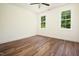 Bright bedroom with hardwood flooring, two windows and white walls at 205 Gentry St, Roxboro, NC 27573