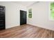 Bedroom featuring hardwood flooring, two windows, and a modern black closet door at 205 Gentry St, Roxboro, NC 27573
