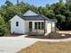 Charming new construction home with white siding, a black metal roof, and a well-manicured lawn at 205 Gentry St, Roxboro, NC 27573