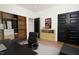 Well-lit home office features a desk, black chair, and unique shelving with decor at 205 Gentry St, Roxboro, NC 27573