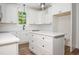 Clean, white kitchen with a kitchen island, modern cabinetry, and stainless steel appliances at 205 Gentry St, Roxboro, NC 27573