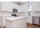 Modern kitchen with white cabinets, stainless steel appliances, and a functional island for meal prep at 205 Gentry St, Roxboro, NC 27573