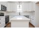 Bright kitchen with island, sleek appliances, white cabinets, and modern finishes perfect for cooking at 205 Gentry St, Roxboro, NC 27573