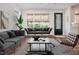 Bright living room features modern sofas, rug, wood floors, and an abundance of natural light from the many windows at 205 Gentry St, Roxboro, NC 27573