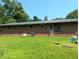 Back exterior of brick home with a metal roof and spacious yard at 2306 Cool Springs Rd, Sanford, NC 27330