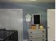 Bright bedroom with crib and a dresser against a blue wall at 2306 Cool Springs Rd, Sanford, NC 27330