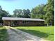 Charming single-story brick home featuring a metal roof, large front yard, and long driveway at 2306 Cool Springs Rd, Sanford, NC 27330