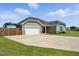 Single-story home with a two-car garage, long driveway, well-kept lawn and fenced in RV parking at 25 Harlow Ct, Fuquay Varina, NC 27526