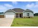 Attractive one-story home with blue siding, stone accents, a two-car garage, and driveway at 25 Harlow Ct, Fuquay Varina, NC 27526