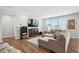 Comfortable living room with a sectional sofa, hardwood floors, and natural light from multiple windows at 25 Harlow Ct, Fuquay Varina, NC 27526