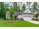 Beautiful home with stone and white siding, lush green lawn, and a tree in the front yard at 2511 Range Overlook Xing, Apex, NC 27523