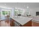 Spacious kitchen island with a sink and dishwasher, pendant lighting, and an adjacent living area at 2511 Range Overlook Xing, Apex, NC 27523