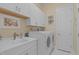 Well-equipped laundry room with modern washer and dryer, ample counter space, and overhead cabinets at 2511 Range Overlook Xing, Apex, NC 27523
