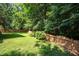 Well-maintained backyard with a wood fence and plenty of shade trees and bushes at 2613 Sweet Gum Dr, Hillsborough, NC 27278