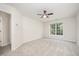 Bright bedroom with neutral carpet, ceiling fan, and large window overlooking green trees at 2613 Sweet Gum Dr, Hillsborough, NC 27278