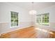 Bright dining room with hardwood floors and two large windows, perfect for entertaining at 2613 Sweet Gum Dr, Hillsborough, NC 27278